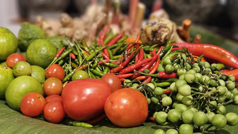 Tomatoes, chilies and limes on a banana leaf