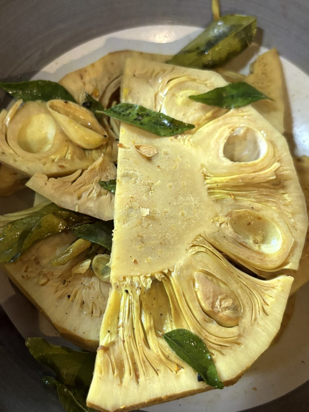 Halved young jackfruit with curry leaves and green chili