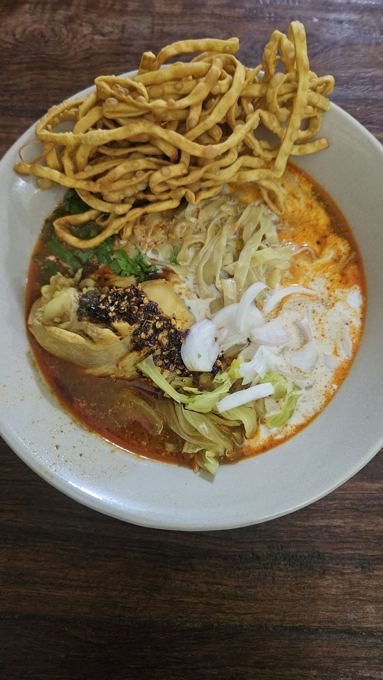 Khao soi from above: coconut curry noodle soup with crispy noodles, pickled greens and shallot