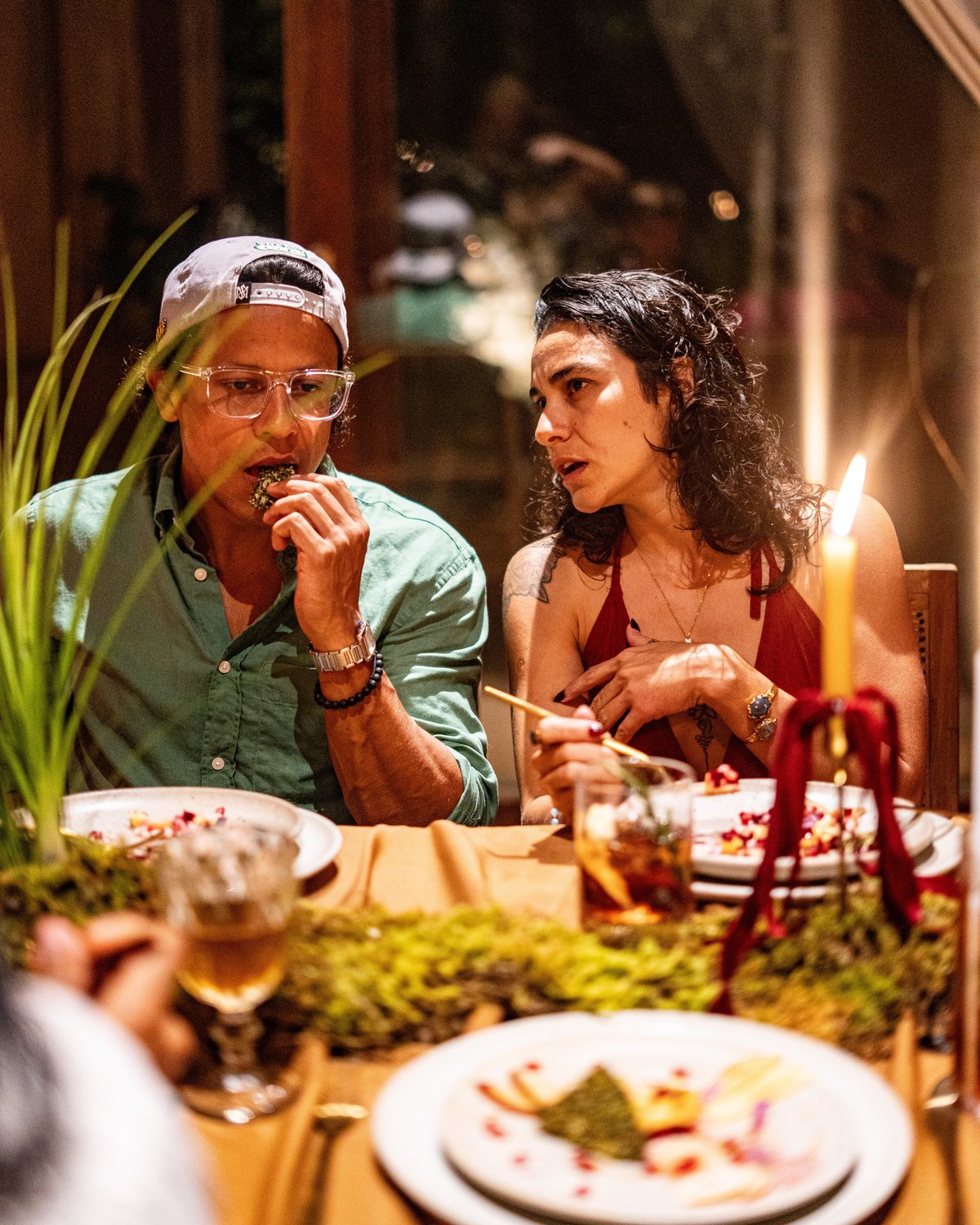 Guests tasting a course by candlelight