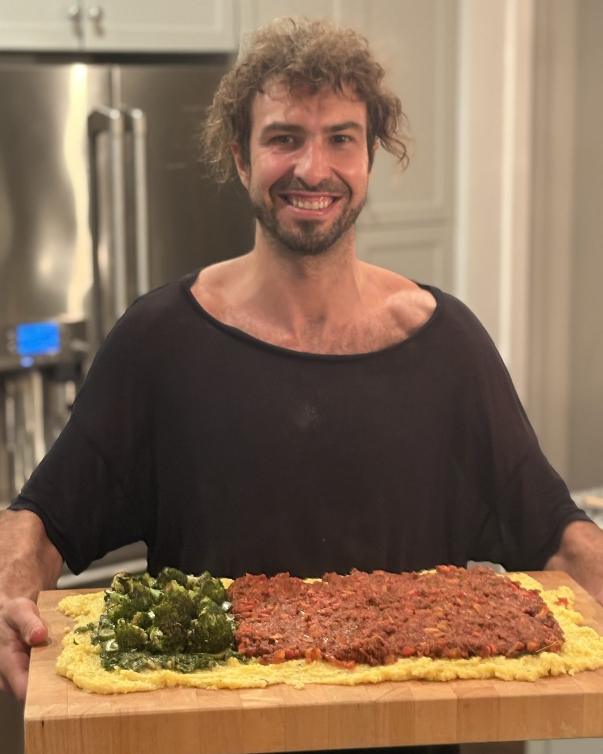 Chef Elliot Fabri carrying a polenta board to a Thanksgiving table
