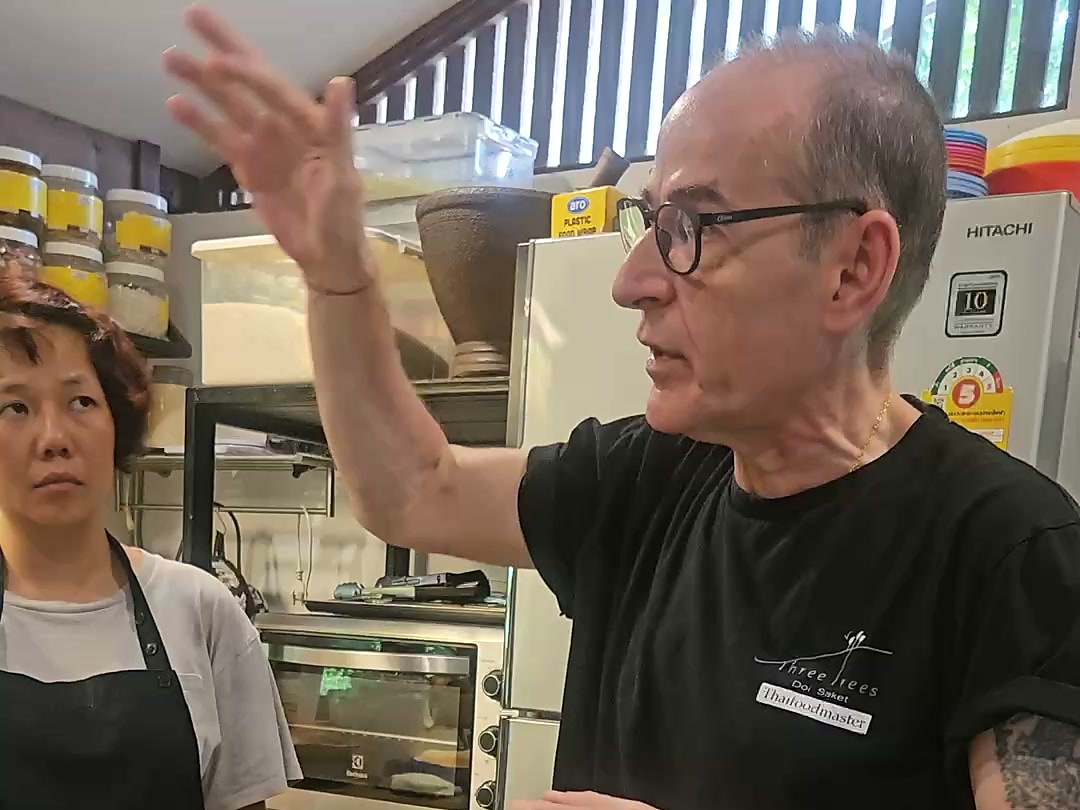 Hanuman Aspler explaining a technique to a student in the Three Trees kitchen