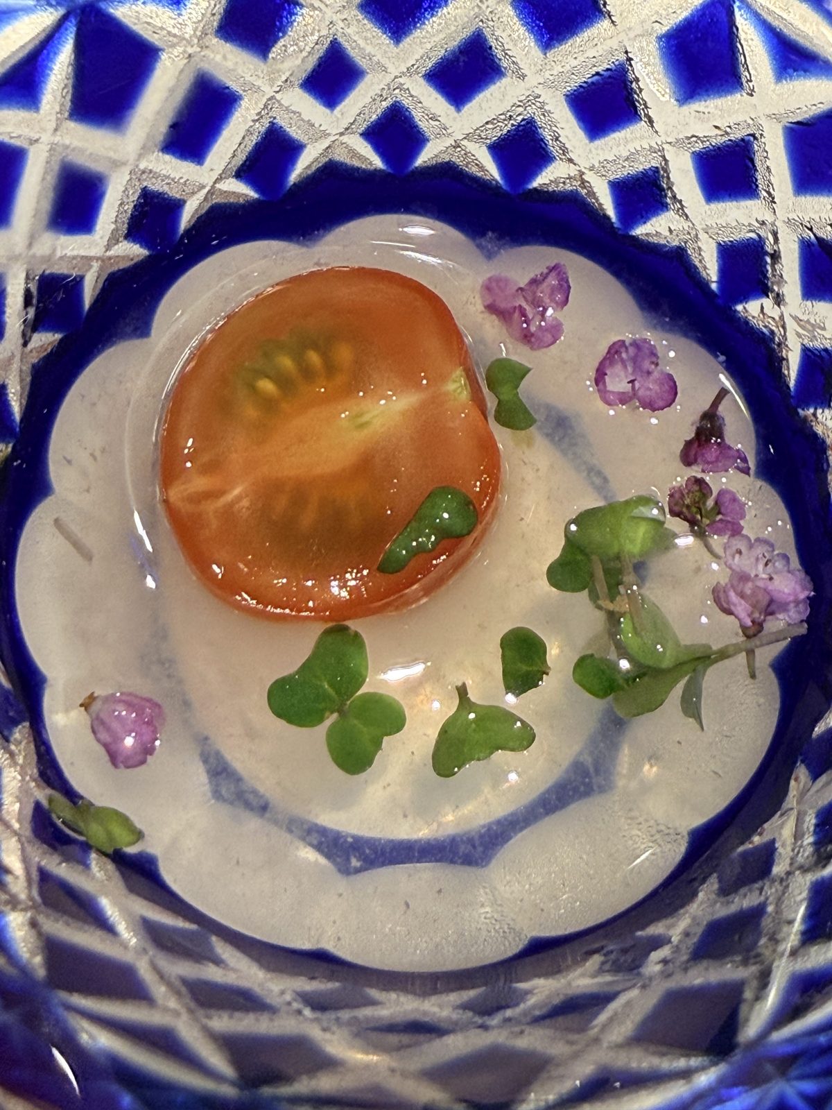 Tomato in dashi jelly with micro-greens in a cobalt kiriko glass