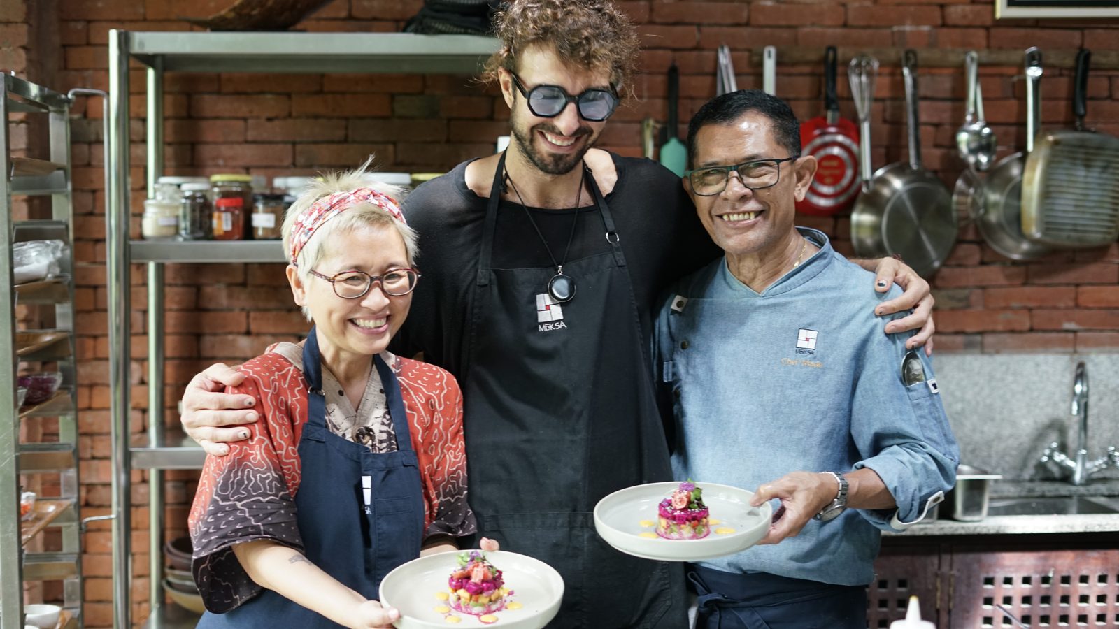 Chef Elliot with Chef Made and a classmate in the Moksa kitchen, holding plated desserts
