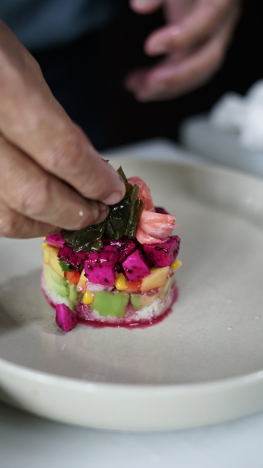 Hands plating the beet tartare